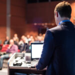 Public speaker giving talk at business event.