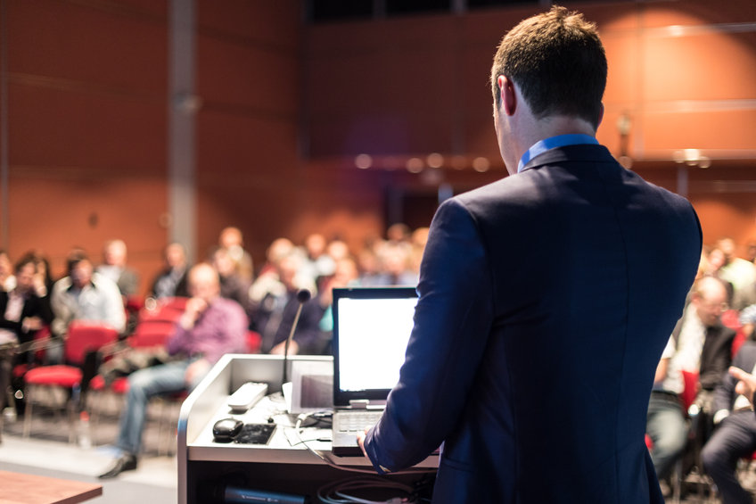 Public speaker giving talk at business event.